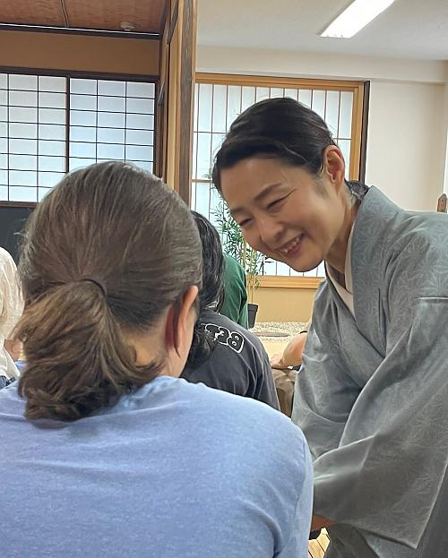 一名日本妇女微笑着给学生端茶